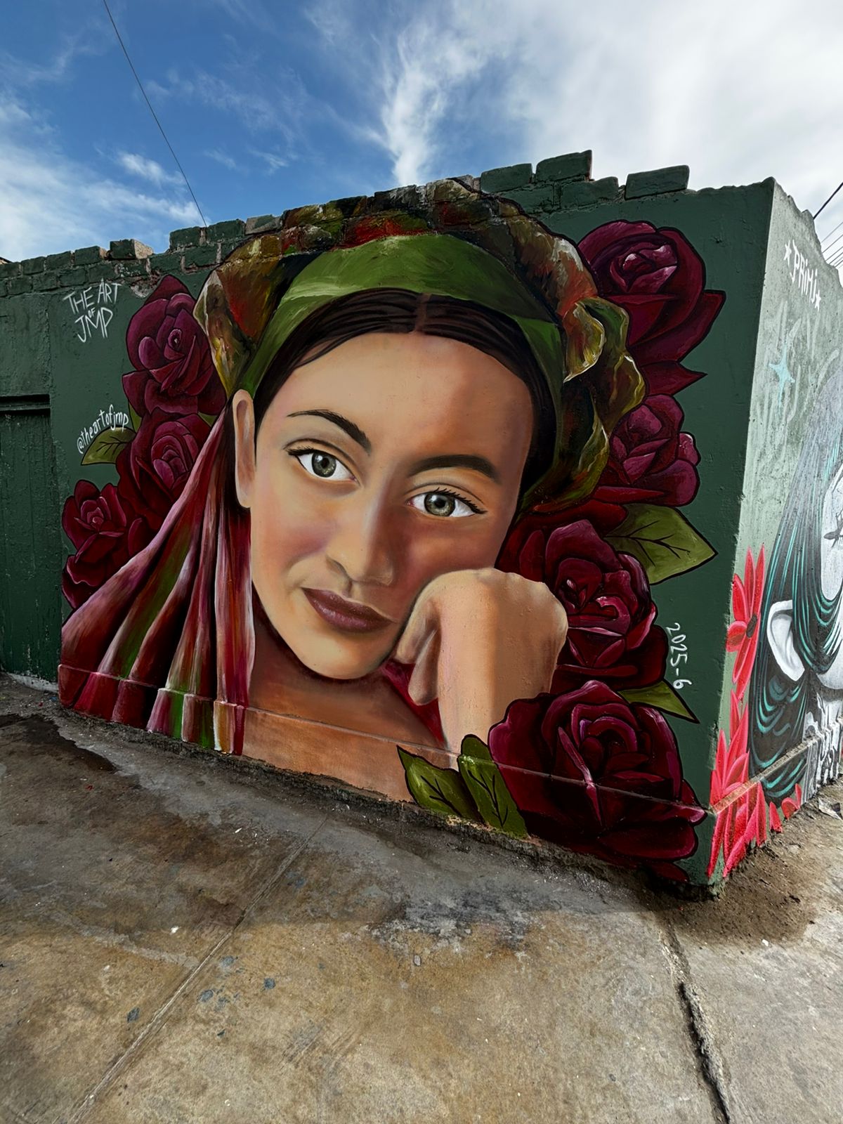 Mural de retrato femenino con pañoleta y rosas