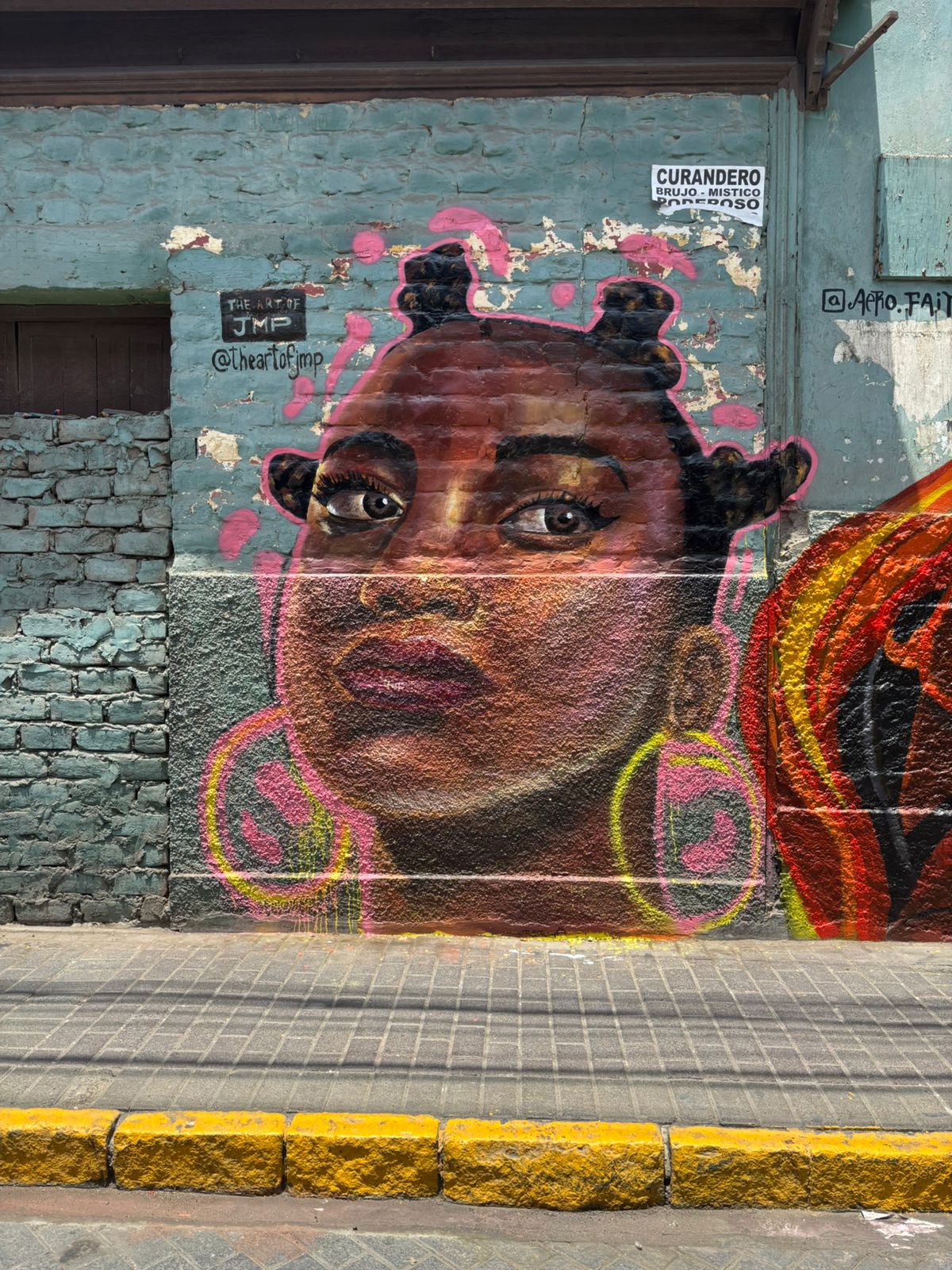Mural de retrato femenino con aretes y fondo rosa